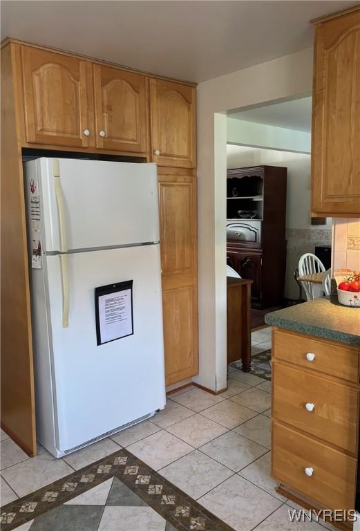 80 Jeffrey Dr, Amherst, NY 14228 - kitchen with freestanding refrigerator, washer / clothes dryer, brown cabinets, tasteful backsplash, and light tile patterned flooring