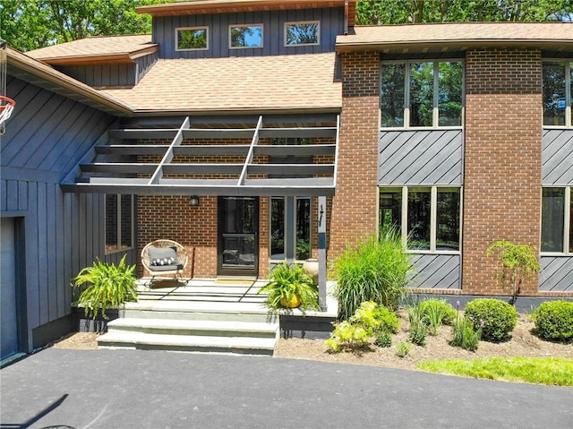 2657 Spencer Hill Rd, Corning, NY 14830 - property entrance featuring board and batten siding, brick siding, and roof with shingles