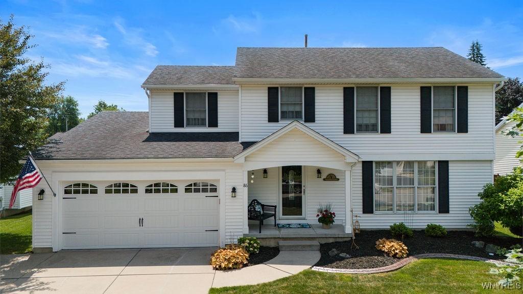 86 Hitching Post Ln, Amherst, NY 14228 - view of front of house featuring a porch, driveway, roof with shingles, and a garage