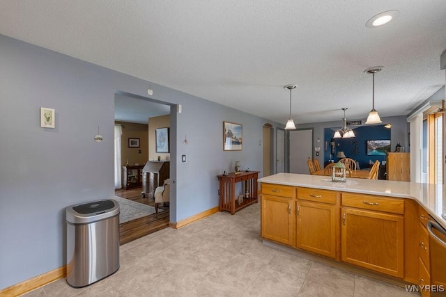 86 Hitching Post Ln, Amherst, NY 14228 - kitchen with a chandelier, light countertops, brown cabinets, decorative light fixtures, and a peninsula