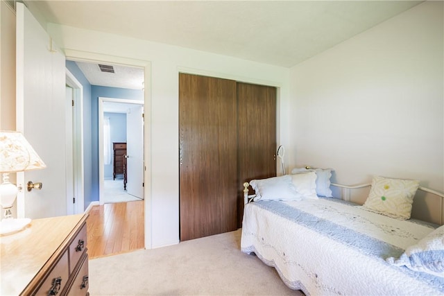 22 Red Leaf Dr, Chili, NY 14624 - bedroom featuring a closet, light carpet, and light wood finished floors