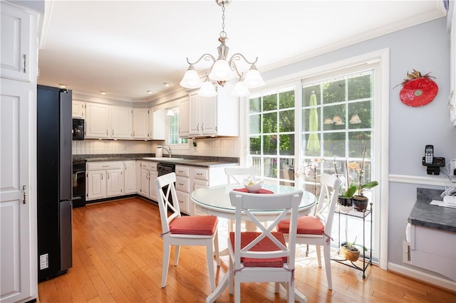 22 Red Leaf Dr, Chili, NY 14624 - kitchen with a chandelier, black appliances, dark countertops, ornamental molding, and backsplash