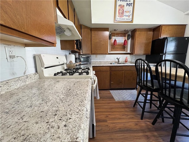 7 E St, Oneonta, NY 13820 - kitchen with under cabinet range hood, brown cabinets, dark wood finished floors, and light countertops