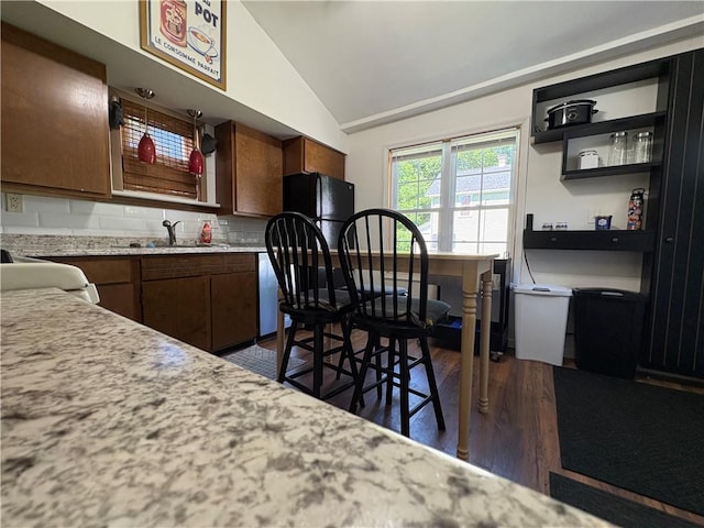 7 E St, Oneonta, NY 13820 - kitchen featuring freestanding refrigerator, light countertops, lofted ceiling, dark wood finished floors, and backsplash
