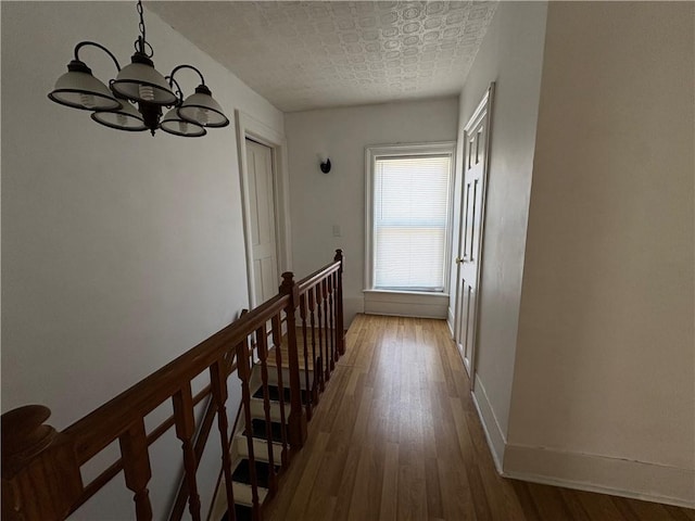 7 E St, Oneonta, NY 13820 - hall featuring a chandelier, wood finished floors, and an upstairs landing