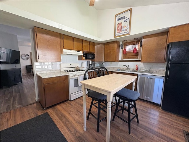 7 E St, Oneonta, NY 13820 - kitchen featuring black appliances, under cabinet range hood, brown cabinets, light countertops, and dark wood-style flooring