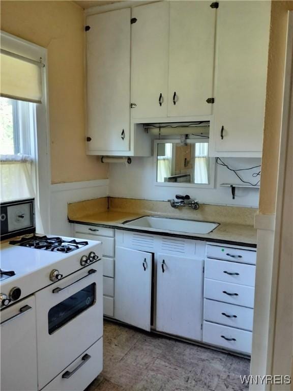 20 Chenango St, Buffalo, NY 14213 - kitchen featuring white gas stove, white cabinetry, and light countertops