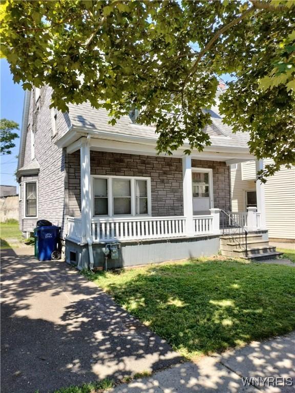 20 Chenango St, Buffalo, NY 14213 - obstructed view of property with covered porch, stone siding, and a shingled roof