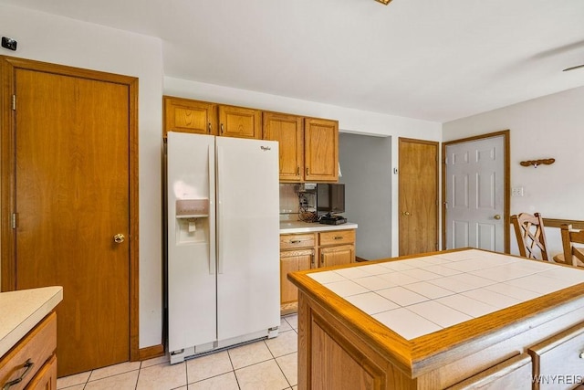 701 Walker Dr, Lewiston, NY 14092 - kitchen featuring white refrigerator with ice dispenser, brown cabinets, tile counters, and light tile patterned floors