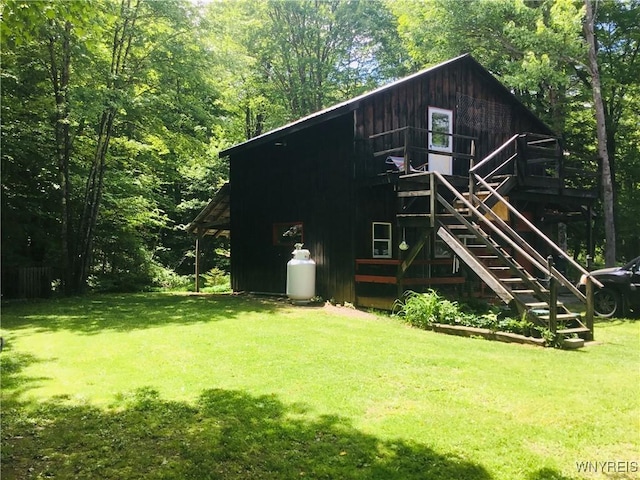9512 Stillwater Rd, Watson, NY 13367 - back of property featuring a lawn, stairway, and a wooded view