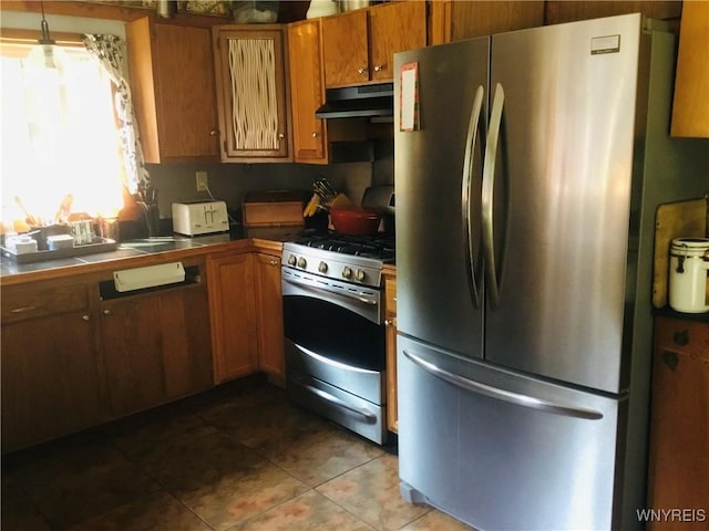 9512 Stillwater Rd, Watson, NY 13367 - kitchen featuring stainless steel appliances, under cabinet range hood, tile patterned flooring, brown cabinets, and tile countertops