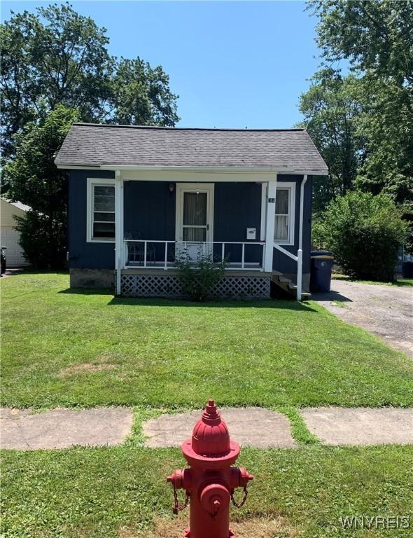 284 W Caledonia St, Lockport City, NY 14094 - bungalow-style house featuring a front yard, covered porch, and roof with shingles