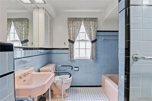 194 Woodridge Ave, Cheektowaga, NY 14225 - bathroom with tile walls, plenty of natural light, a tub, wainscoting, and a shower