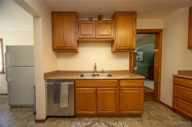 368 Cayuga Creek Rd, Cheektowaga, NY 14227 - kitchen with stainless steel dishwasher, freestanding refrigerator, arched walkways, and brown cabinets