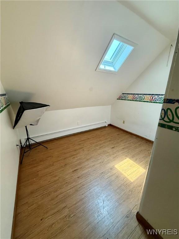 80 Fredro St, Buffalo, NY 14206 - bonus room with a skylight, vaulted ceiling, wood finished floors, and baseboard heating