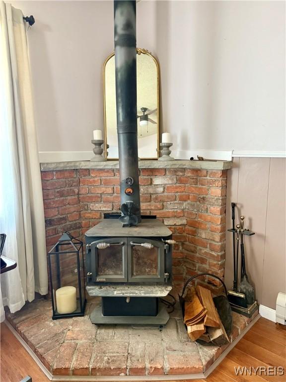 80 Fredro St, Buffalo, NY 14206 - detailed view of a wood stove, wood finished floors, and a wainscoted wall