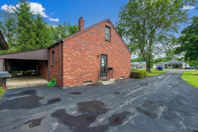 473 Seneca Creek Rd, West Seneca, NY 14224 - view of side of home with brick siding, driveway, a chimney, a carport, and entry steps