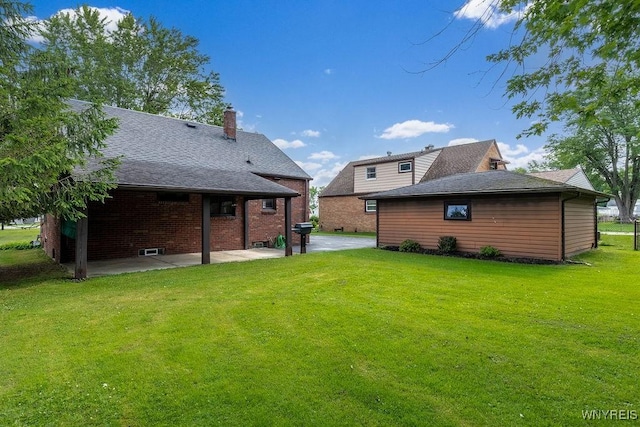 473 Seneca Creek Rd, West Seneca, NY 14224 - back of house featuring a patio area, a lawn, a shingled roof, and a chimney