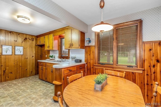 473 Seneca Creek Rd, West Seneca, NY 14224 - kitchen featuring wooden walls, wallpapered walls, light countertops, brown cabinets, and light flooring