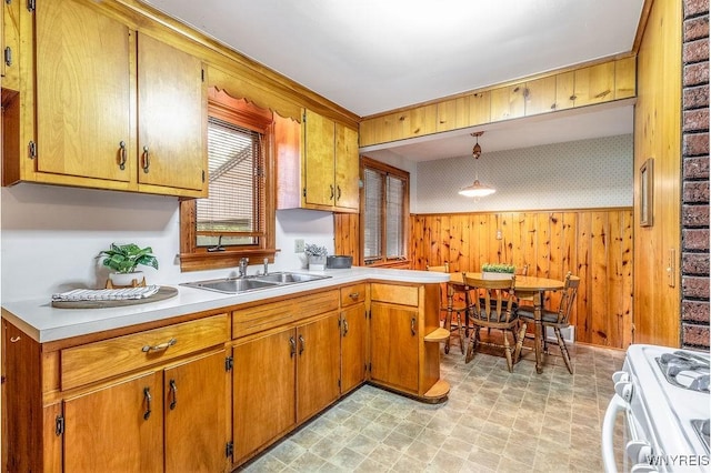 473 Seneca Creek Rd, West Seneca, NY 14224 - kitchen featuring white gas range, light countertops, brown cabinetry, decorative light fixtures, and wooden walls
