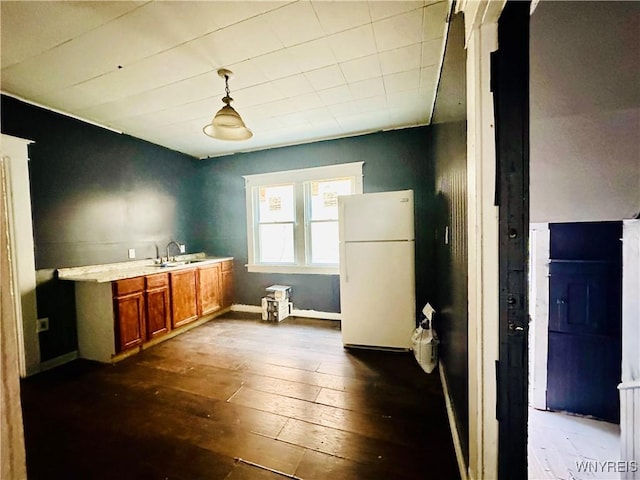 67 Holmes St, Buffalo, NY 14207 - kitchen featuring freestanding refrigerator, brown cabinetry, dark wood finished floors, light countertops, and pendant lighting