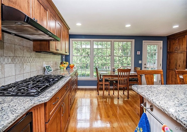 101 Luan Cir, Dewitt, NY 13078 - kitchen with under cabinet range hood, black gas cooktop, light wood-style floors, recessed lighting, and light stone countertops