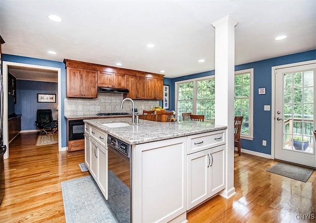 101 Luan Cir, Dewitt, NY 13078 - kitchen with under cabinet range hood, light wood finished floors, tasteful backsplash, recessed lighting, and light stone countertops
