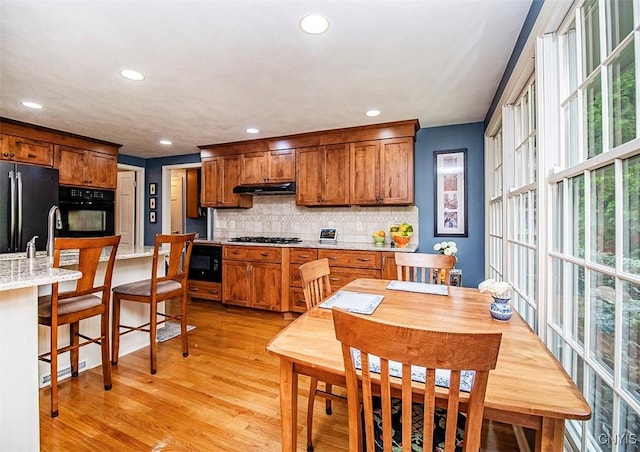 101 Luan Cir, Dewitt, NY 13078 - kitchen featuring black appliances, under cabinet range hood, recessed lighting, light wood finished floors, and decorative backsplash