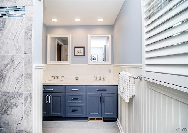 101 Luan Cir, Dewitt, NY 13078 - bathroom featuring double vanity, a wainscoted wall, tile patterned floors, and a decorative wall