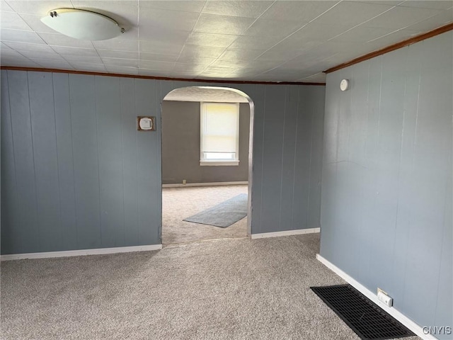 231 N Main St, Oneida, NY 13421 - carpeted empty room featuring arched walkways, crown molding, and wood walls