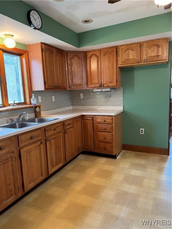 45 Clio Ave, Buffalo, NY 14220 - kitchen featuring brown cabinets, light countertops, decorative backsplash, and light flooring