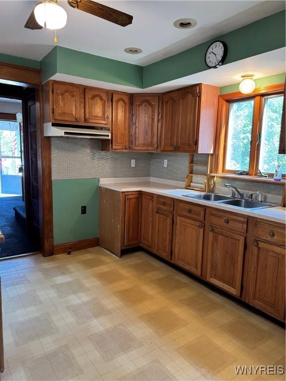 45 Clio Ave, Buffalo, NY 14220 - kitchen featuring under cabinet range hood, healthy amount of natural light, and brown cabinetry