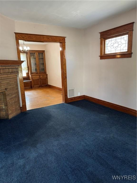 45 Clio Ave, Buffalo, NY 14220 - unfurnished living room with carpet flooring and a chandelier