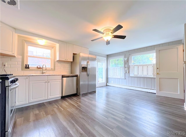 60 Waltham Ave, Lancaster, NY 14086 - kitchen with stainless steel appliances, a baseboard heating unit, light wood finished floors, ceiling fan, and light countertops
