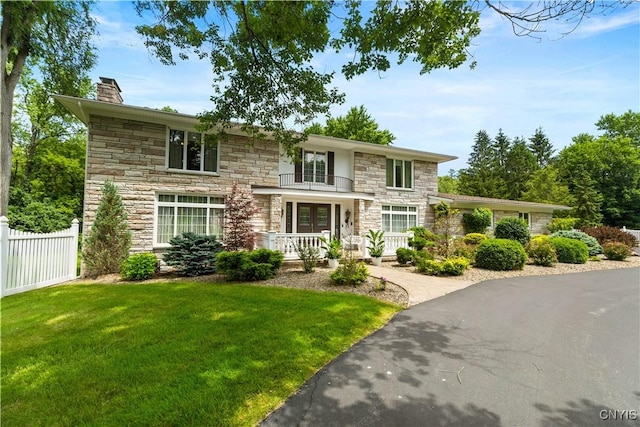 5 Hingham Rd, Utica, NY 13501 - view of front of home featuring stone siding, a chimney, covered porch, and a balcony