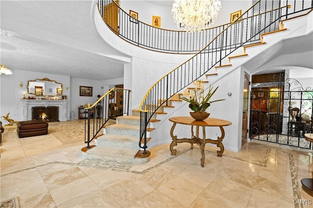 5 Hingham Rd, Utica, NY 13501 - staircase with a chandelier, a lit fireplace, arched walkways, a towering ceiling, and a textured ceiling