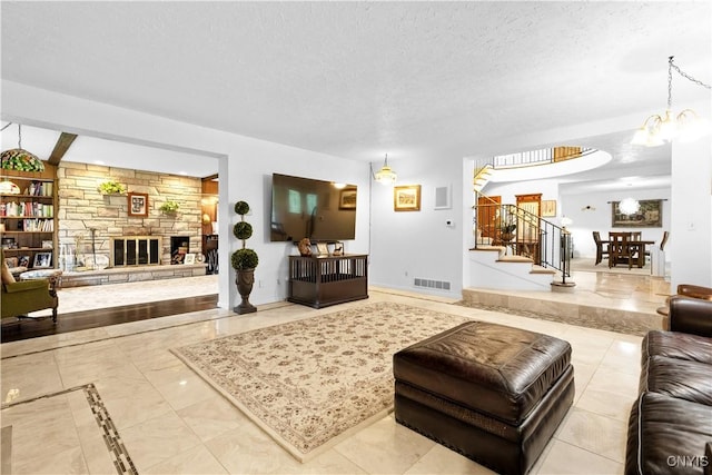 5 Hingham Rd, Utica, NY 13501 - living room featuring stairs, a textured ceiling, a chandelier, and a fireplace