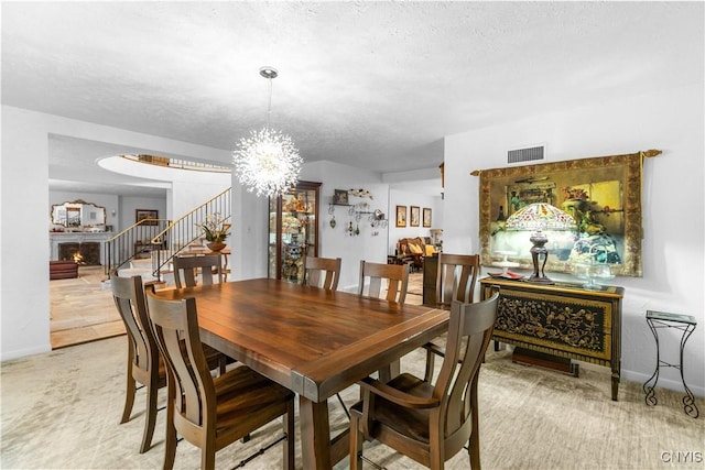 5 Hingham Rd, Utica, NY 13501 - dining area with stairway, a chandelier, a textured ceiling, and a warm lit fireplace