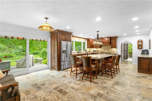 5 Hingham Rd, Utica, NY 13501 - dining space featuring arched walkways, stone tile flooring, recessed lighting, and a textured ceiling