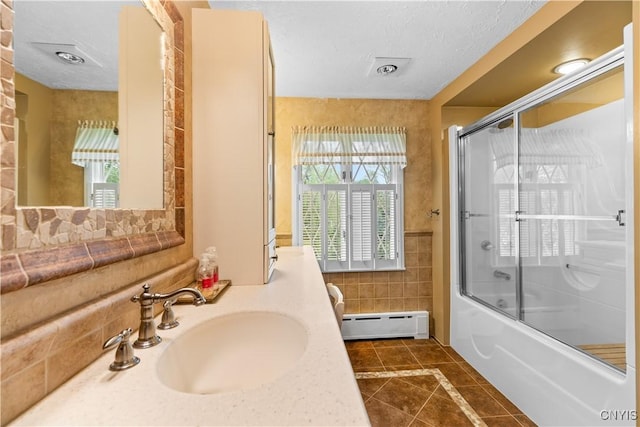 5 Hingham Rd, Utica, NY 13501 - full bathroom featuring a baseboard heating unit, tile patterned flooring, tile walls, shower / bath combination with glass door, and vanity