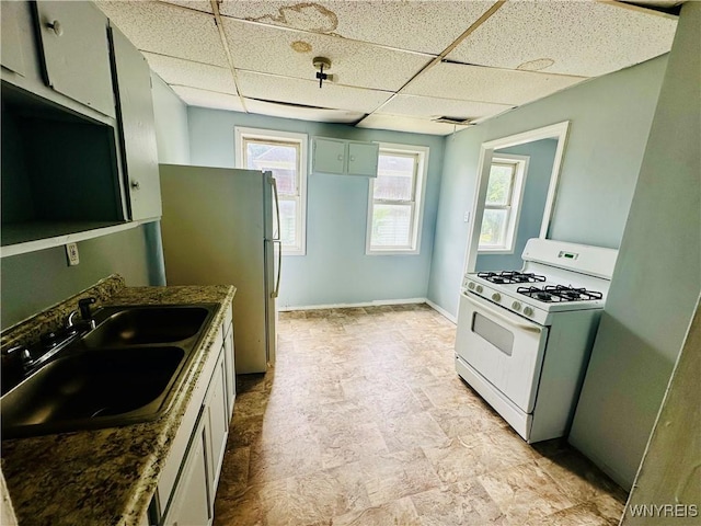 253 Gold St, Buffalo, NY 14206 - kitchen with white range with gas stovetop, a drop ceiling, and dark countertops