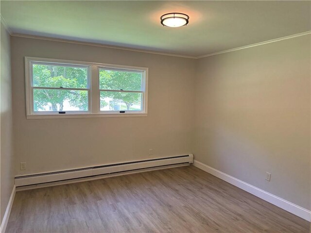 6365 Honey Run Rd, Hornellsville, NY 14843 - spare room with baseboard heating, healthy amount of natural light, crown molding, and wood finished floors