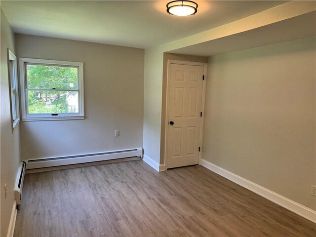 6365 Honey Run Rd, Hornellsville, NY 14843 - spare room featuring wood finished floors, baseboard heating, and a baseboard radiator