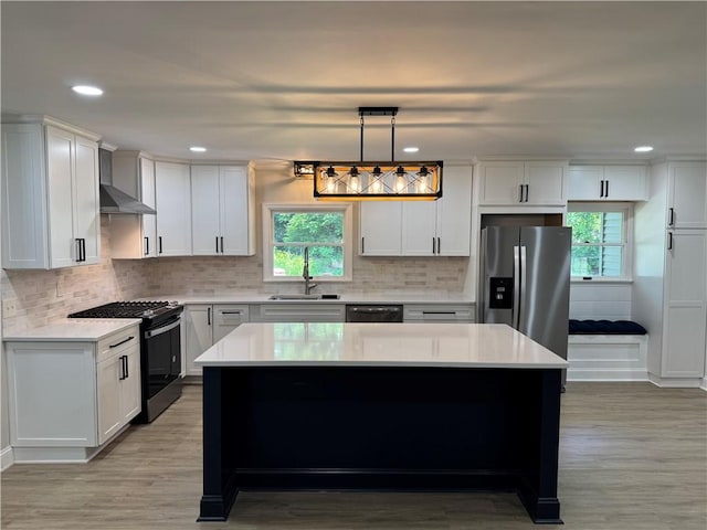 6365 Honey Run Rd, Hornellsville, NY 14843 - kitchen with gas range, stainless steel fridge, wall chimney range hood, light countertops, and dishwashing machine