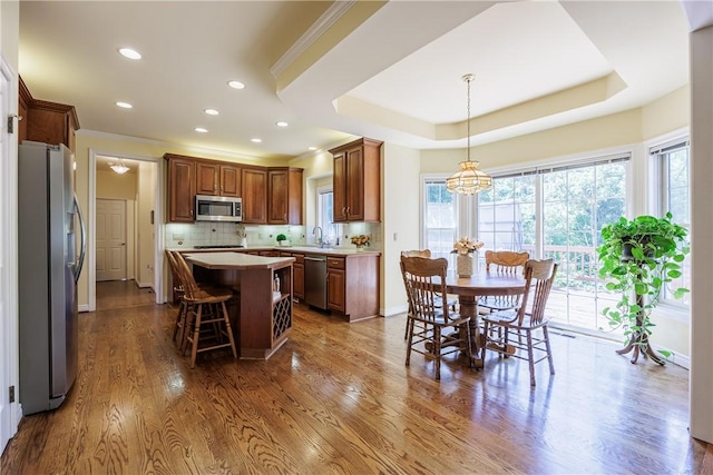 117 Neuchatel Ln, Perinton, NY 14450 - kitchen featuring appliances with stainless steel finishes, light countertops, a kitchen island, decorative backsplash, and a kitchen breakfast bar