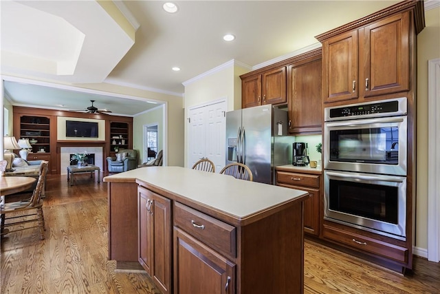 117 Neuchatel Ln, Perinton, NY 14450 - kitchen with stainless steel appliances, a center island, ornamental molding, wood finished floors, and a ceiling fan