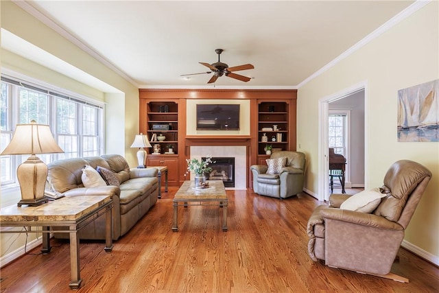 117 Neuchatel Ln, Perinton, NY 14450 - living area featuring built in shelves, crown molding, a fireplace, ceiling fan, and wood finished floors