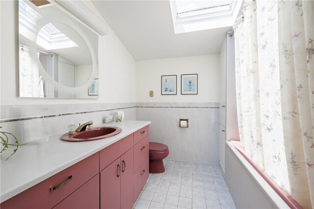 125 Sunset Dr, Brighton, NY 14618 - full bathroom featuring vanity, tile walls, a skylight, tile patterned floors, and shower / bath combination with curtain