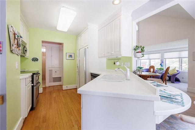 125 Sunset Dr, Brighton, NY 14618 - kitchen with white cabinets, appliances with stainless steel finishes, a peninsula, and light countertops