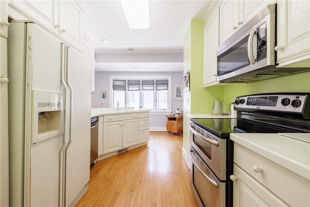 125 Sunset Dr, Brighton, NY 14618 - kitchen with stainless steel appliances, light wood-type flooring, light countertops, white cabinetry, and recessed lighting